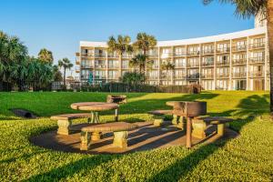 a park with tables and benches in front of a building at Pirates Bay A113 in Fort Walton Beach