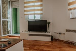 a living room with a large flat screen tv at David 2 in Ruma +15 photos