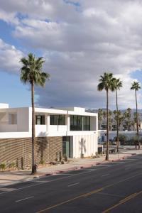 a building with palm trees in front of a street at Drift Palm Springs in Palm Springs