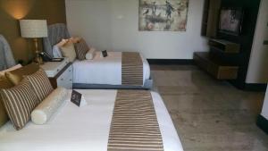 a hotel room with two beds and a couch at Resort Vidanta Riviera Maya in Puerto Morelos