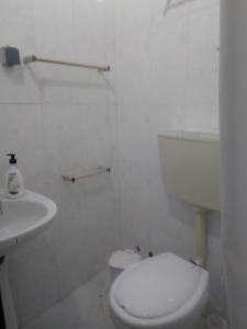 a white bathroom with a toilet and a sink at Casa Aires Varela in Elvas