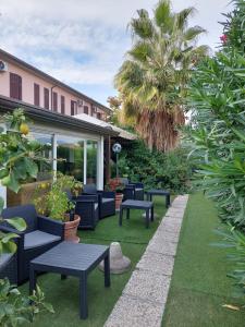 a garden with benches and plants on the grass at Hotel Patrizia in Marina di Massa