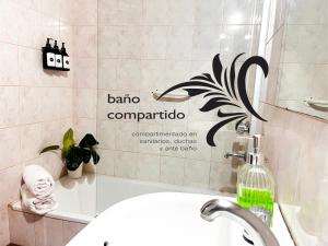un baño con lavabo y un cartel en la pared en Calchaquíes Home Hostel en San Salvador de Jujuy
