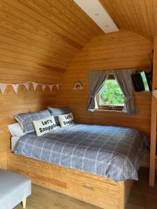 1 dormitorio con 1 cama en una habitación de madera en Wildflower Meadow Cabins, en Whitington