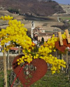 un ramo de flores amarillas con un pueblo en el fondo en Agriturismo Mondo, en Bubbio