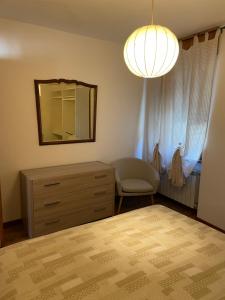 1 dormitorio con tocador, espejo y silla en Nel Borgo, en Verrès