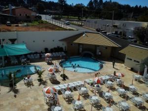 una vista aérea de una piscina con mesas y sombrillas en Diroma Exclusive Flats Para Temporada, en Caldas Novas