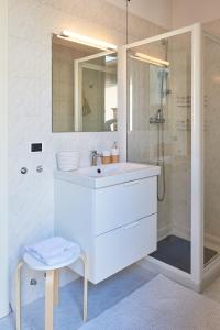 a white bathroom with a sink and a shower at Residenza Jasmine - La Guarida in Udine
