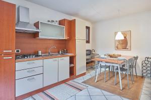 a kitchen with a table and a sink and a counter at Residenza Jasmine - La Guarida in Udine