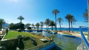 a resort with palm trees and a body of water at APARTAMENTO VISTAZUL SAMIL in Vigo