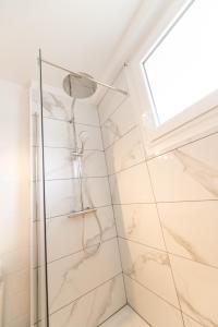 een badkamer met een douche en marmeren tegels bij LE DAUPHIN - Place parking privée gratuit - WIFI et TV in Saint-Étienne
