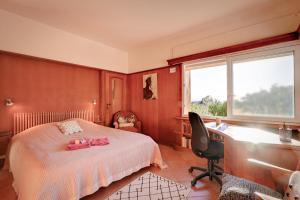 a bedroom with a bed and a desk and a window at Les Iles D'Or in Rayol-Canadel-sur-Mer