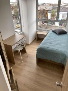 a bedroom with a bed and a desk and a window at UhaUs Coliving 302 - Apto 12 habitaciones in Manizales