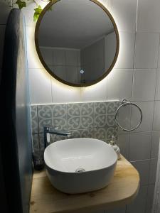 a bathroom with a white sink and a mirror at Daphné Village House - close to Methana & Poros in Methana