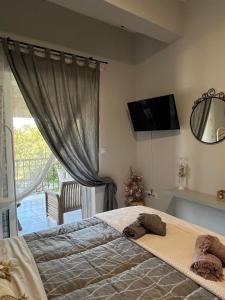 a bedroom with a bed and a tv on the wall at Daphné Village House - close to Methana & Poros in Methana
