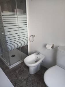 a white bathroom with a toilet and a shower at Apartamento cerca del puerto y del paseo in Grao de Castellón
