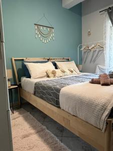 two beds in a bedroom with blue walls at Daphné Village House - close to Methana & Poros in Methana