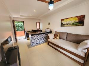 uma sala de estar com um sofá e uma cozinha em Pousada Camarás em Alto Paraíso de Goiás