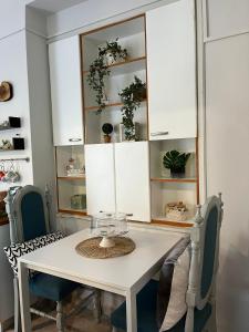 comedor con mesa blanca y sillas en Daphné Village House - close to Methana & Poros, en Metana