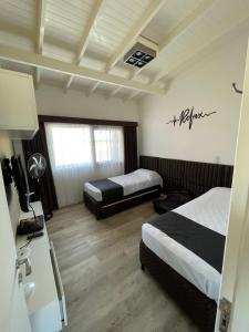 Habitación de hotel con 2 camas y TV en Chacras del Mar en Balneario Mar Azul