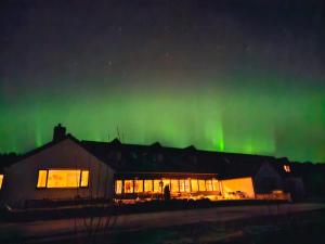 a building with the aurora in the sky at Delny Muir House in Invergordon