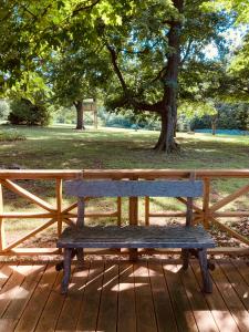 eine Holzbank auf einem Deck in einem Park in der Unterkunft High Meadows Estate in Purcellville