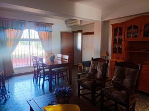 a living room with a dining room table and chairs at Casa con Piscina Privada y Barbacoa en Chiclana Capacidad hasta 10 personas in Chiclana de la Frontera
