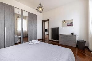 a bedroom with a white bed and a television at Il Loft di Vanni in Vicenza