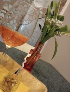 un jarrón con una flor junto a una copa de vino en La Mimosa, en Porto Garibaldi