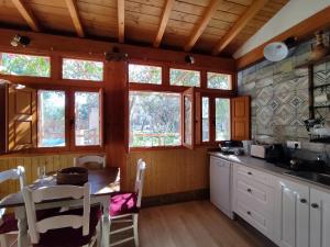 cocina con mesa y algunas ventanas en Apartamento El Grifo, en Carmona