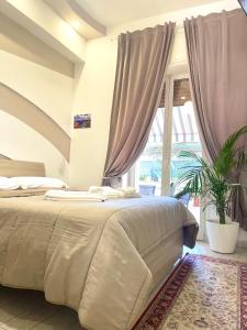 a bedroom with a large bed and a large window at Terrazza Garibaldi in Naples