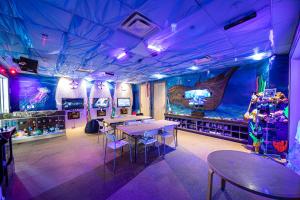 een eetkamer met tafels en een groot aquarium bij Vibrant Home by Rentyl Near Disney with Private Pool, Themed Room & Resort Amenities - 401N in Orlando
