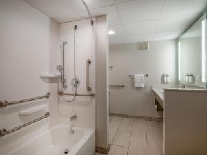 Holiday Inn Express & Suites Greensboro - I-40 atWendover, an IHG Hotel في جرينسبورو: حمام مع حوض استحمام ودش ومغسلة