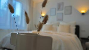 a white vase with feathers in a room with a bed at Hotel Fewotal & Luxury 5 - nähe Messe Düsseldorf & Köln in Wuppertal