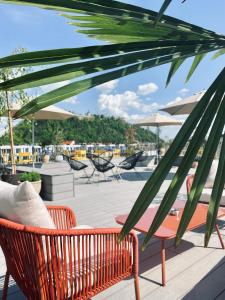 un patio con banco, sillas y sombrillas en Lendhotel en Graz