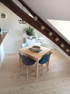 een houten tafel en stoelen in een kamer met een trap bij Appartement de charme Amboise in Amboise