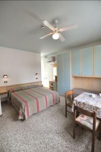 a bedroom with two beds and a ceiling fan at Hotel Residence Villa Lily in Cesenatico