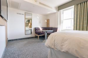 Schlafzimmer mit einem Bett, einem Schreibtisch und einem Fenster in der Unterkunft Club Quarters Hotel Covent Garden Holborn, London in London