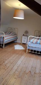 een slaapkamer met 2 bedden en een houten vloer bij Appartement de charme Amboise in Amboise