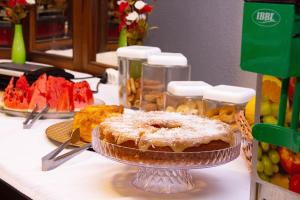 einen Tisch mit einem Kuchen auf einem Tisch mit Obst in der Unterkunft HOTEL DOMHOF in Blumenau