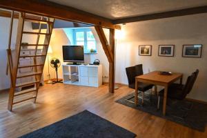 a living room with a ladder and a table and a television at Haus Weihertor in Traben-Trarbach +10 photos