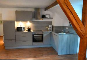 a kitchen with a stove and a microwave at Haus Weihertor in Traben-Trarbach