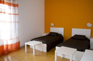 サンタ・クローチェ・カメリーナにあるVilla Cappuzzello Montalbanoのベッド2台、テーブル、窓が備わる客室です。