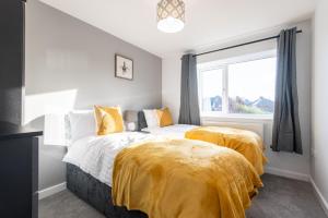 2 bedden in een slaapkamer met gele dekens bij No203 in Doncaster