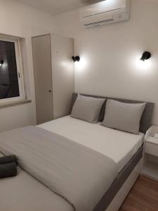 uma cama branca num quarto com uma janela em Lisbon South Bay Rooms em Almada