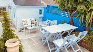 Cowes Cottage في كاوز: فناء مع طاولة بيضاء وكراسي