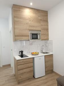 a kitchen with a sink and a microwave at Hotel Posada del Mar in Suances