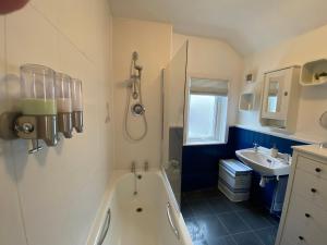 a bathroom with a tub and a sink at Cowes Cottage in Cowes