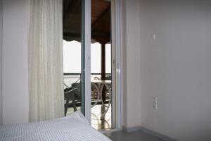1 dormitorio con cama y vistas a un balcón en Eleftheria, en Menídion