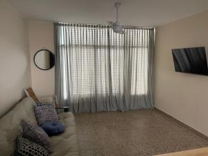 sala de estar con sofá y ventana grande en ApartSanMartin561 en Reconquista